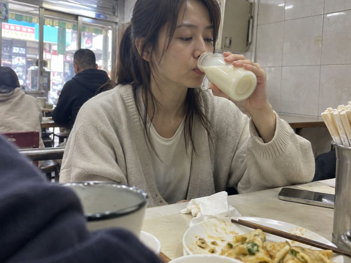 AI生成照片案例：朋友亂拍型，早餐店喝豆漿沒看鏡頭、前景有遮擋的真實感照片